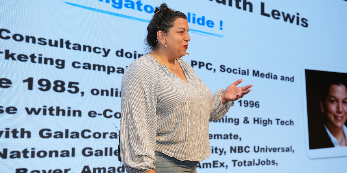 Judith Lewis presenting “AI-enhanced SEO Reporting for Smarter Strategic Insights” on stage at Search ’n Stuff Antalya 2025 conference.