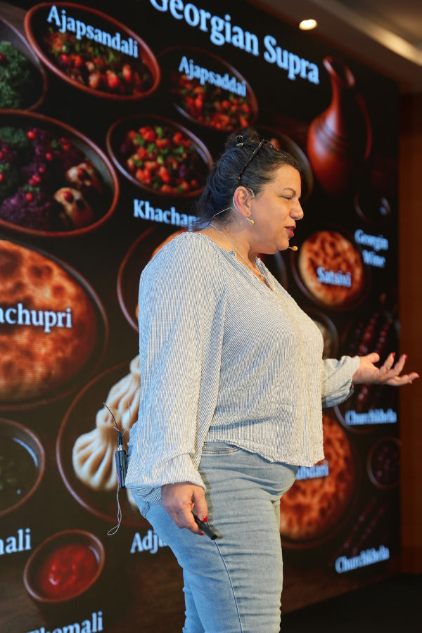 Judith Lewis presenting “AI-enhanced SEO Reporting for Smarter Strategic Insights” on stage at Search ’n Stuff Antalya 2025 conference.